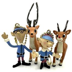 three small figurines are standing next to each other with antlers on their heads