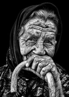 an old woman with wrinkles holding a cane