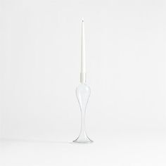 Milano reimagines classic candlesticks in clear glass, streamlining the ornate curves to stunning effect. Hand-blown by skilled craftspeople, this tall candle holder culminates in an elongated cup that supports a taper or double as a bud vase. Display the sophisticated piece solo for a sculptural look, or layer with our exclusive Milano and Venezia glass taper holders in various heights for a more extravagant effect. Due to artisanal crafting, each small candlestick is beautifully unique.     Ha Taper Candles With Glass Sleeves, Clear Taper Candle Holder, Taper Candle In Glass Cylinder, Silver Taper Candle Holder, Tall Candle Holder, Glass Taper Candle Holders, Tall Candle Holders, Vase Display, Taper Holders