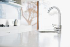 a white kitchen counter top with a faucet