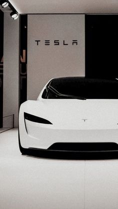 an electric car is parked in a white room with the word tesla written on it