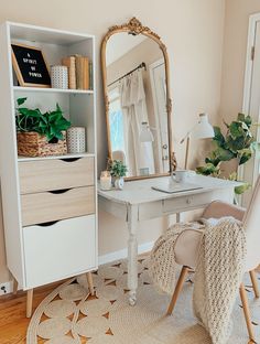 a white desk and chair in a room with a large mirror on the wall above it