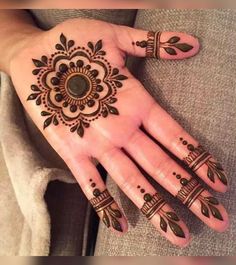 a woman's hand with henna tattoos on it