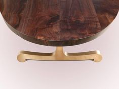 a wooden table with metal legs and a round top that has been made to look like wood