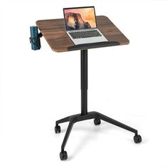 a laptop computer sitting on top of a wooden table next to a black metal frame