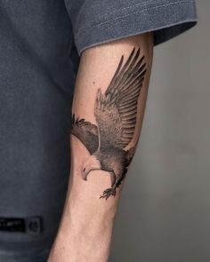 a man's arm with an eagle tattoo on it