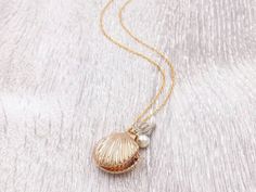 "A lovely and beautiful gold seashell locket necklace. It features a shining gold seashell along with white conch and pearl. The pearl is genuine Swarovski 6mm pearl. It suspends in a gold finished brass chain along with lobster claw clasp closure. The shell locket inside can hold pictures in both side 16mm x 14mm. It is a wonderful idea for gift giving or as a little treat for yourself. Your necklace will present in a gift box and tied with ribbon. Measurements and details: Length: 16\", 18\", Seashell Locket, Melody Mermaid, Shell Locket, Prom Hair Accessories, Gold Locket Necklace, Hair Accessories Gift, Wedding Keepsakes, Shell Pendant, Locket Necklace