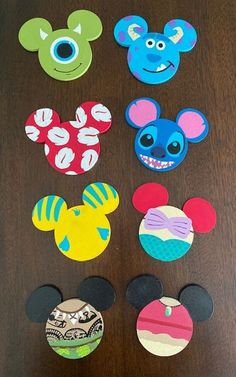 mickey mouse and friends magnets on a wooden table with the faces of each character