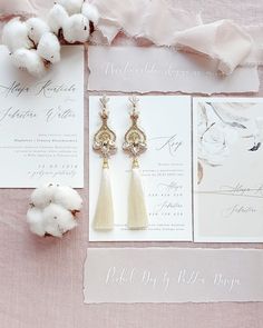 the wedding stationery is laid out with cotton