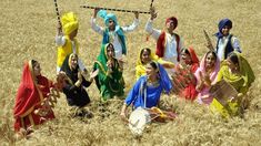 some people are standing in the middle of a wheat field and one is holding something