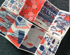 four folded papers with red, blue and white designs on them sitting on the floor