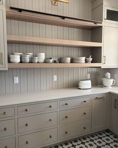 the kitchen is clean and ready to be used for cooking or baking, with dishes on the shelves