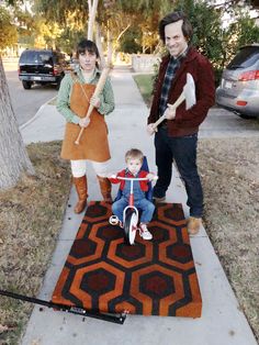 two adults and a child standing on a rug