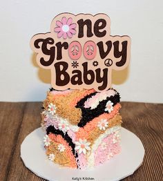 a cake that is sitting on top of a plate with a one grooy baby sign