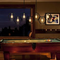 a pool table with lights hanging from it