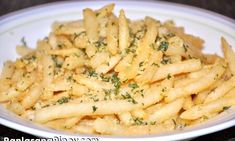 a white plate topped with french fries covered in parmesan cheese and seasoning