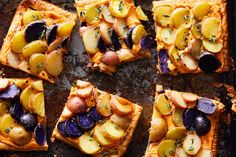 several square pizzas with different toppings on a baking sheet