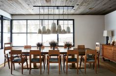 a dining room table and chairs in front of a large window