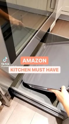 a person is opening an oven door with the words amazon kitchen must have on it