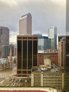 an aerial view of the city with tall buildings and cars parked in front of them