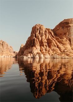 the water is calm and clear with rocks in the backgrouds on either side