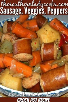 a bowl filled with sausage, veggies, peppers and carrots on top of a wooden table