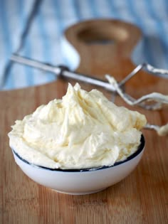 a bowl filled with whipped cream on top of a wooden table