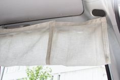 the inside of a car with two white curtains