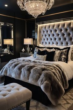 a bedroom with a large bed, chandelier and mirror on the wall above it