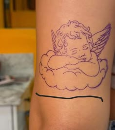 a tattoo on the leg of a woman with an angel sitting on top of it