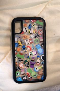 an iphone case with many cartoon characters on it sitting on top of a white sheet