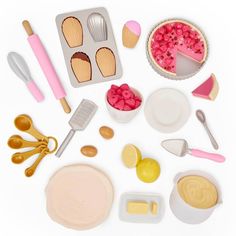 an assortment of kitchen utensils and baking supplies on a white surface with pink accents