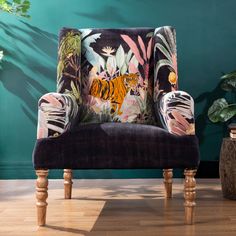 an upholstered chair in front of a green wall with a tiger print on it