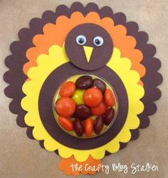 a turkey made out of candy sitting on top of a table next to a bowl filled with candies