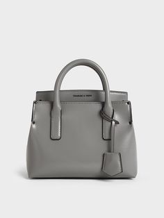 The Rene bag is the epitome of classic style, featuring double top handles, clean lines, a trapeze shape and a structured base. This version, in a light grey finish, offers a refreshing alternative to classic black while remaining equally elegant and versatile. Secured by a magnetic closure, it will keep your everyday essentials secure yet easily accessible. Carry the Rene by its sturdy top handles for a polished look, or use the adjustable shoulder strap for additional styling options. Structured Top, Charles Keith, Handle Bag, Everyday Essentials, Polished Look, Magnetic Closure, Clean Lines, Classic Black, Top Handle