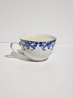 a blue and white porcelain cup filled with liquid