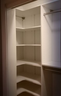 an empty white closet with shelves and cupboards in the corner, viewed from inside