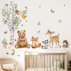 a baby's room with animals and trees on the wall