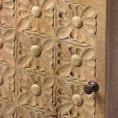 the door is made out of wood and has decorative carvings on it