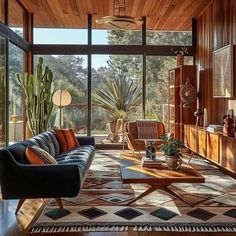 a living room filled with lots of furniture and plants on top of a wooden floor