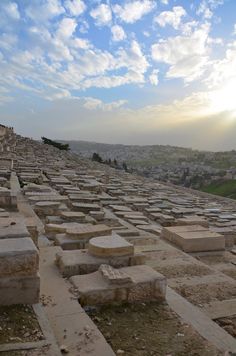 the sun is shining over an ancient city with many headstones in front of it