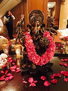 an elephant statue surrounded by flowers and candles