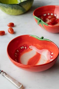 two red bowls sitting on top of a white counter