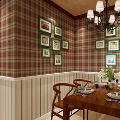 a dining room table with place settings and pictures on the wall