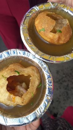 two small pies sitting on top of tin foil covered pans filled with food