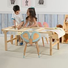 two children playing with wooden toys in a playroom