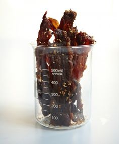 a glass measuring cup filled with bacon strips