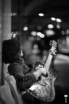 a person sitting on a bench with a guitar in their hand and the caption reads, i am not sure what this is