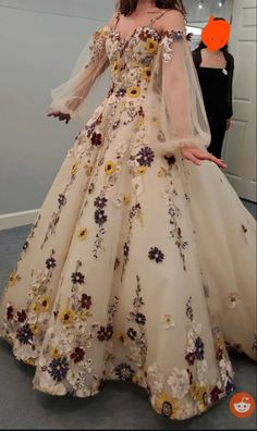 a woman in a wedding dress with flowers on it and an orange sticker behind her