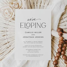 a wedding card with the words we're eloping on it next to some flowers